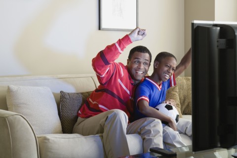 Father and Son (12-13) watching sports on tv. Photo: Rob Lewine