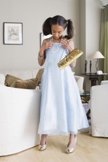 Girl (10-11) trying on elegant clothes. Photo : Rob Lewine