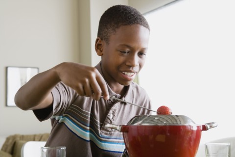 Boy (12-13) preparing dessert. Photo : Rob Lewine
