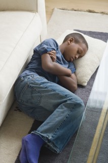 Boy (12-13) sleeping on carpet. Photo: Rob Lewine