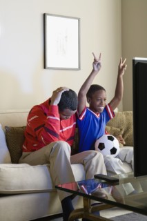 Father and Son (12-13) watching sports on tv. Photo: Rob Lewine