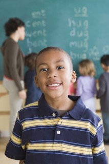 Portrait of boy (6-7) with schoolmates in background. Photo : Rob Lewine