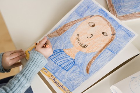 Girl (6-7) drawing portrait. Photo : Rob Lewine