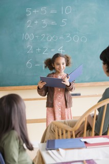 Girl (6-7) having presentation in classroom. Photo : Rob Lewine