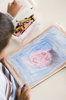 Boy (6-7) drawing in classroom. Photo : Rob Lewine