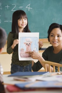 Girl (6-7) showing her drawing in classroom. Photo : Rob Lewine