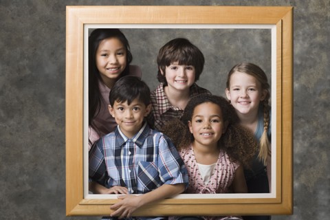 Children (6-7, 8-9) posing together in frame, studio shot. Photo: Rob Lewine