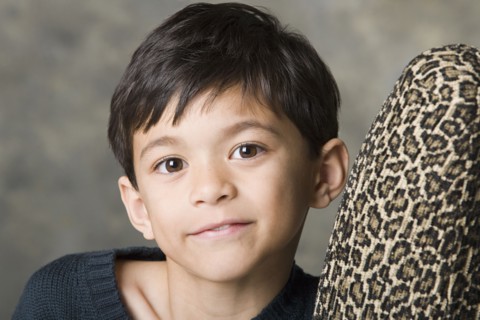 Portrait of smiling boy (8-9) looking at camera, studio shot. Photo : Rob Lewine