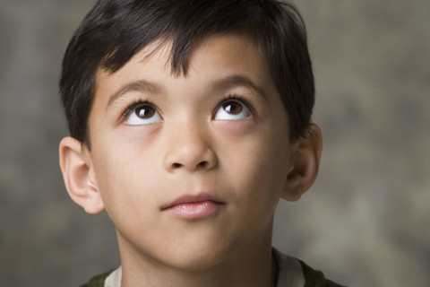 Portrait of smiling boy (8-9) looking up, studio shot. Photo : Rob Lewine