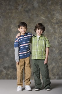 Two boys (6-7, 8-9) standing together, studio shot. Photo : Rob Lewine