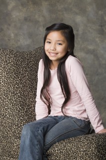 Portrait of smiling girl (8-9), studio shot. Photo : Rob Lewine