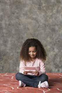 Girl (8-9) playing game, studio shot. Photo : Rob Lewine