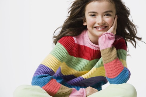 Portrait of smiling girl (8-9), studio shot. Photo : Rob Lewine