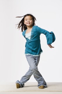 Smiling girl (8-9) dancing, studio shot. Photo : Rob Lewine