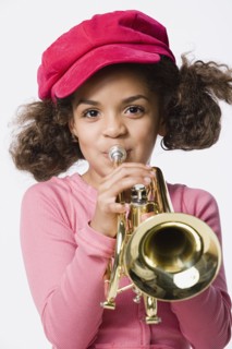 Portrait of girl (8-9) playing trumpet, studio shot. Photo: Rob Lewine