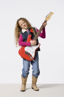 Studio shot of girl (8-9) playing electric guitar, studio shot. Photo : Rob Lewine