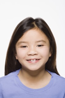 Portrait of smiling girl (8-9), studio shot. Photo : Rob Lewine