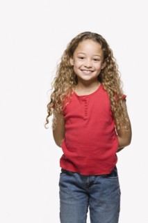 Portrait of smiling girl (8-9), studio shot. Photo : Rob Lewine