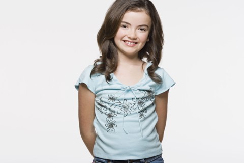 Portrait of smiling girl (8-9), studio shot. Photo : Rob Lewine