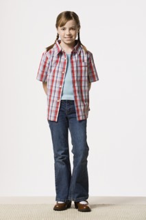 Portrait of smiling girl (8-9) wearing checked shirt, studio shot. Photo : Rob Lewine