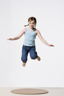 Studio portrait of girl (8-9) jumping. Photo : Rob Lewine