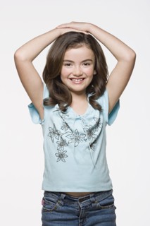 Studio portrait of smiling girl (8-9). Photo : Rob Lewine