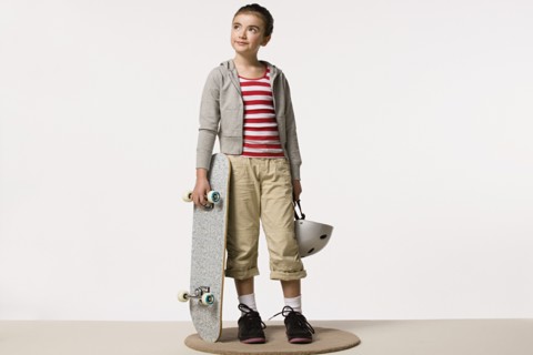 Studio portrait of girl (8-9) with skateboard. Photo : Rob Lewine