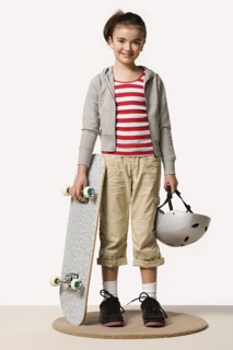 Studio portrait of girl (8-9) with skateboard. Photo : Rob Lewine