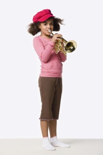 Studio portrait of girl (8-9) playing trumpet. Photo: Rob Lewine