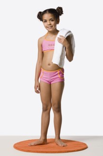 Studio portrait of girl (8-9) in bikini holding towel. Photo: Rob Lewine