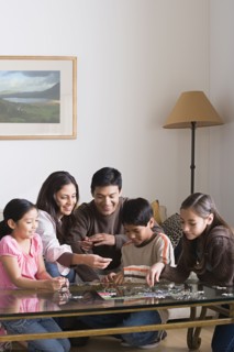 Family with three children (8-9, 10-11) playing with puzzle. Photo : Rob Lewine
