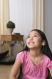 Portrait of smiling girl (8-9) with headphones. Photo : Rob Lewine