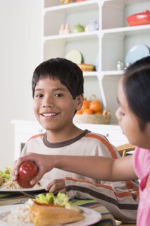 Portrait of smiling boy (10-11) and girl (8-9) dining at table. Photo : Rob Lewine