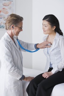 Female doctor examining woman. Photo : Rob Lewine