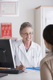 Smiling female doctor talking to patient in her office. Photo: Rob Lewine