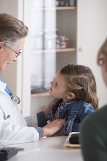 Female doctor talking to small girl (4-5) in her office. Photo: Rob Lewine
