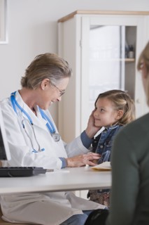 Female doctor stroking small girl (4-5). Photo: Rob Lewine