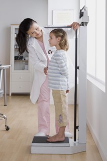 Female doctor measuring small girl (4-5). Photo : Rob Lewine