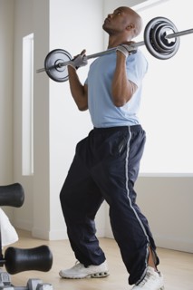 Man lifting barbell in gym. Photo : Rob Lewine