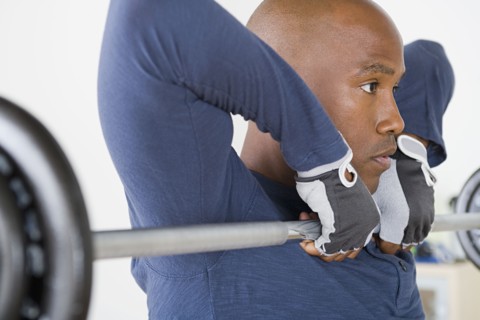 Man lifting barbell in gym. Photo : Rob Lewine