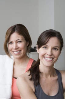 Portrait of two smiling women in gym. Photo : Rob Lewine