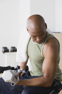 Young man lifting weights in gym. Photo : Rob Lewine