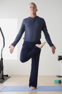 Mature man practicing yoga on mat. Photo : Rob Lewine
