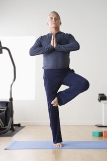 Mature man practicing yoga on mat. Photo : Rob Lewine