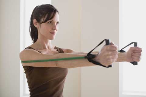 Woman exercising with resistance band. Photo : Rob Lewine
