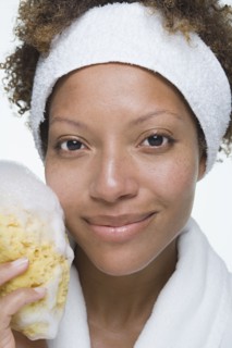 Portrait of attractive woman holding bath sponge. Photo : Rob Lewine