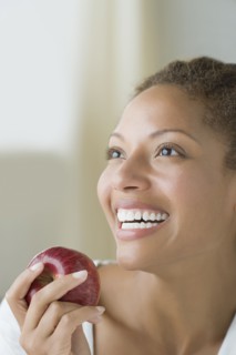 Attractive woman holding apple. Photo : Rob Lewine
