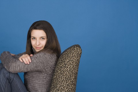 Portrait of teenage girl (16-17) sitting on chair. Photo : Rob Lewine