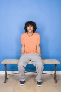 Portrait of teenage boy (14-15) sitting on bench. Photo : Rob Lewine