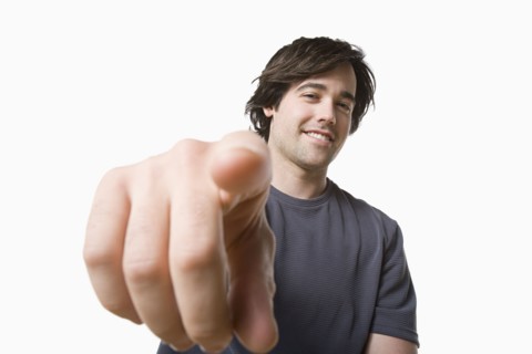 Studio portrait of young man pointing. Photo: Rob Lewine